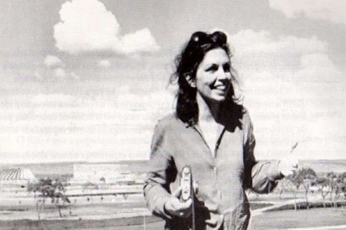 Maria Elisa Costa em Brasília, sorrindo, com a cidade ao fundo