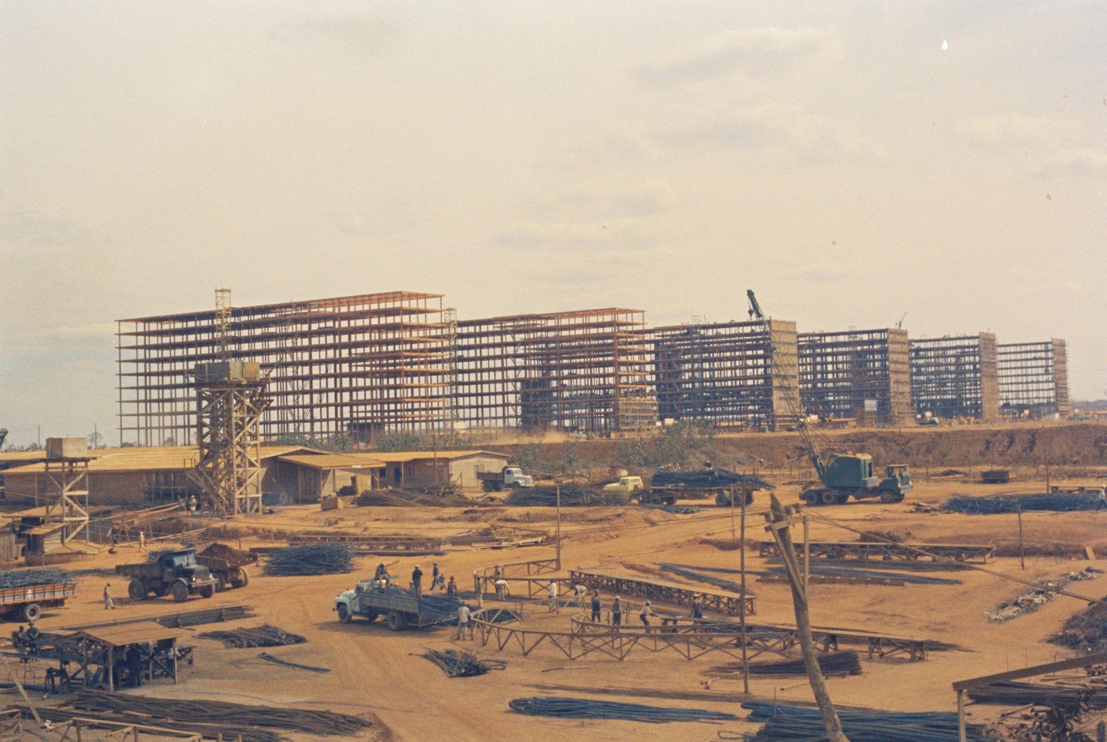 Canteiro de obras dos ministérios da Esplanada, com estruturas metálicas, caminhões e operários